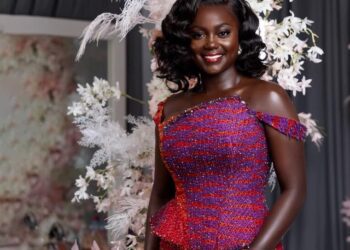 A bride in her two piece engagement kente posed for the camera. Its a half picture