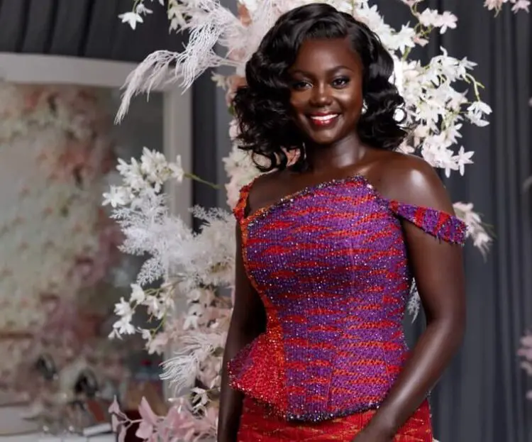 A bride in her two piece engagement kente posed for the camera. Its a half picture