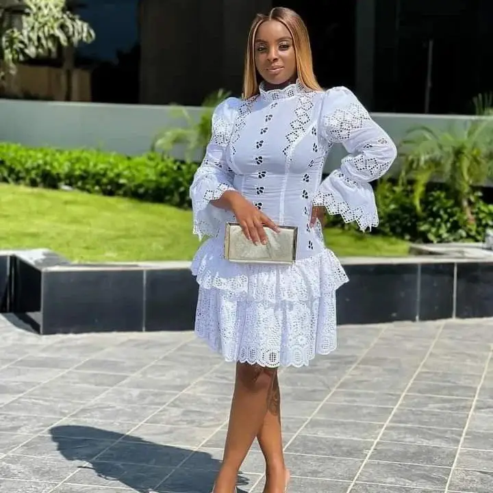 A lady in a wedding guest white lace dress styles in Ghana 