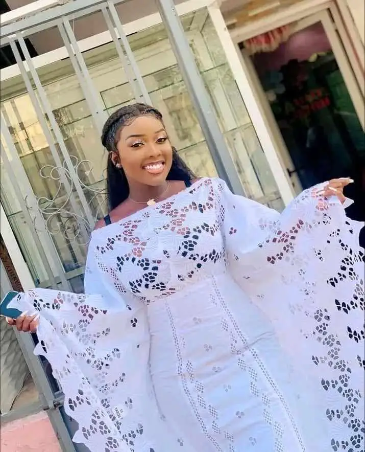 A young lady in wedding guest white lace dress styles in Ghana 