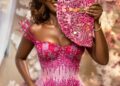 bride in pink kente holding a fan